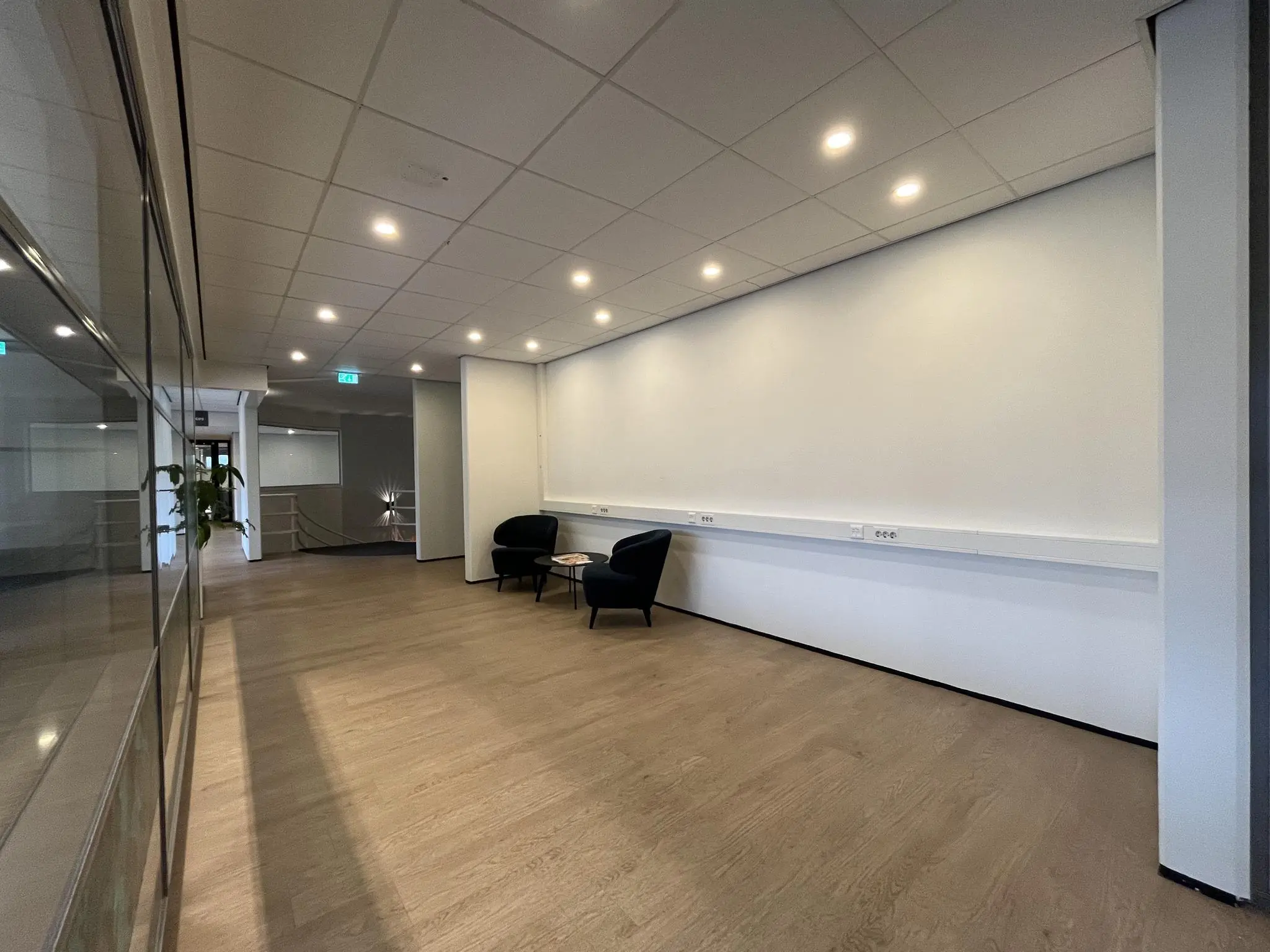 Moderne wachtruimte in het kantoor van burgemeester Verderlaan met twee stoelen en een bijzettafel.